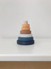 A Mini Wooden Pyramid Stacker - Desert Night with six rings in varying sizes and colors, coated in non-toxic paint, arranged in order from largest at the bottom to smallest on top, set against a plain white background.